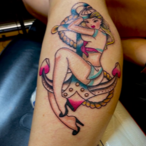 A tattoo of a woman sitting on an anchor