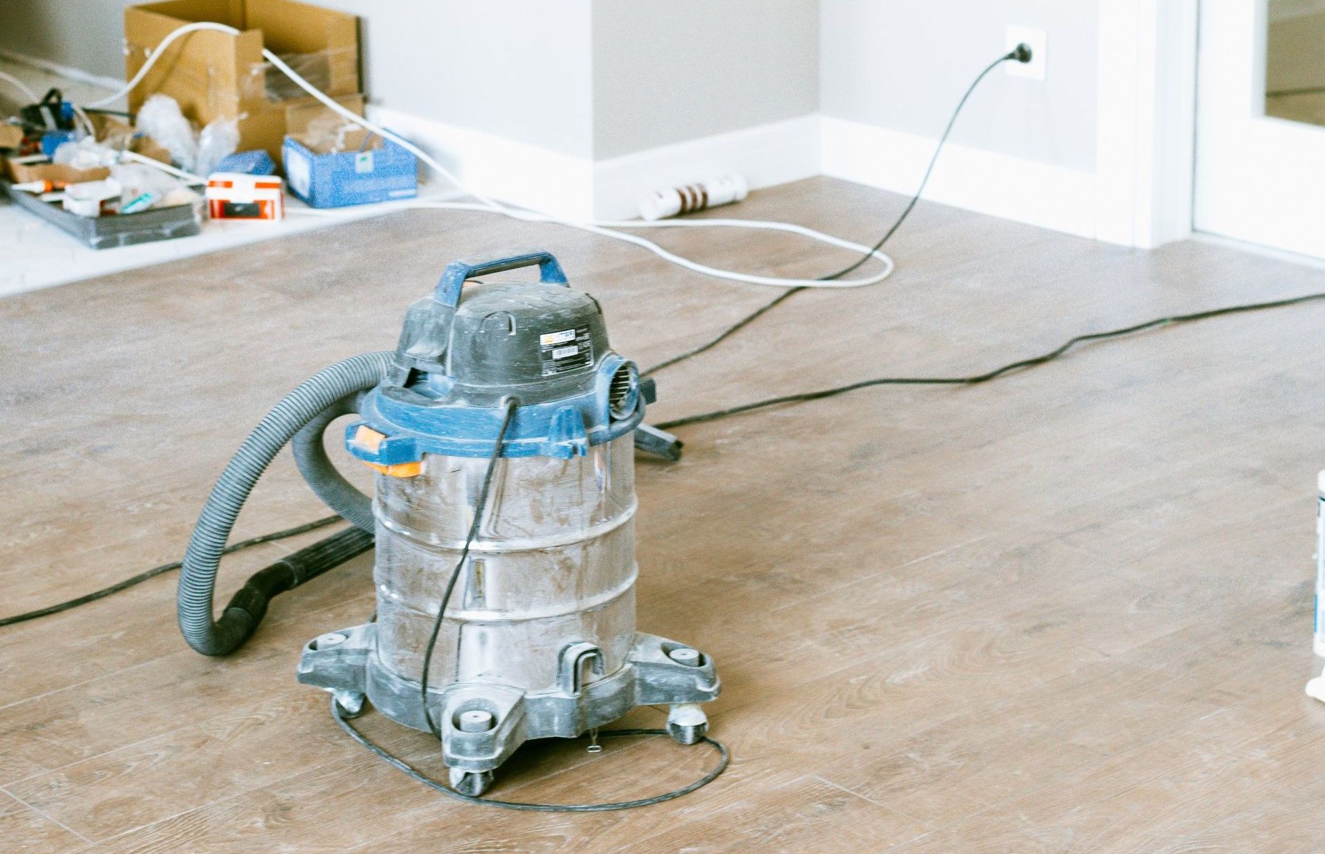 A vacuum cleaner is sitting on a wooden floor in a room.