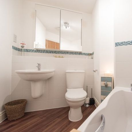 A general view of a bathroom interior of a home with white tiles