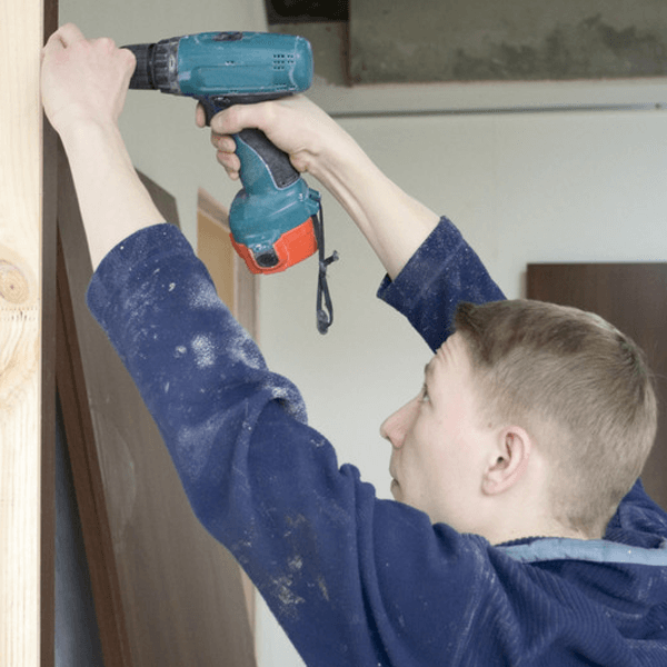 master installs door. drilling the hole for screw