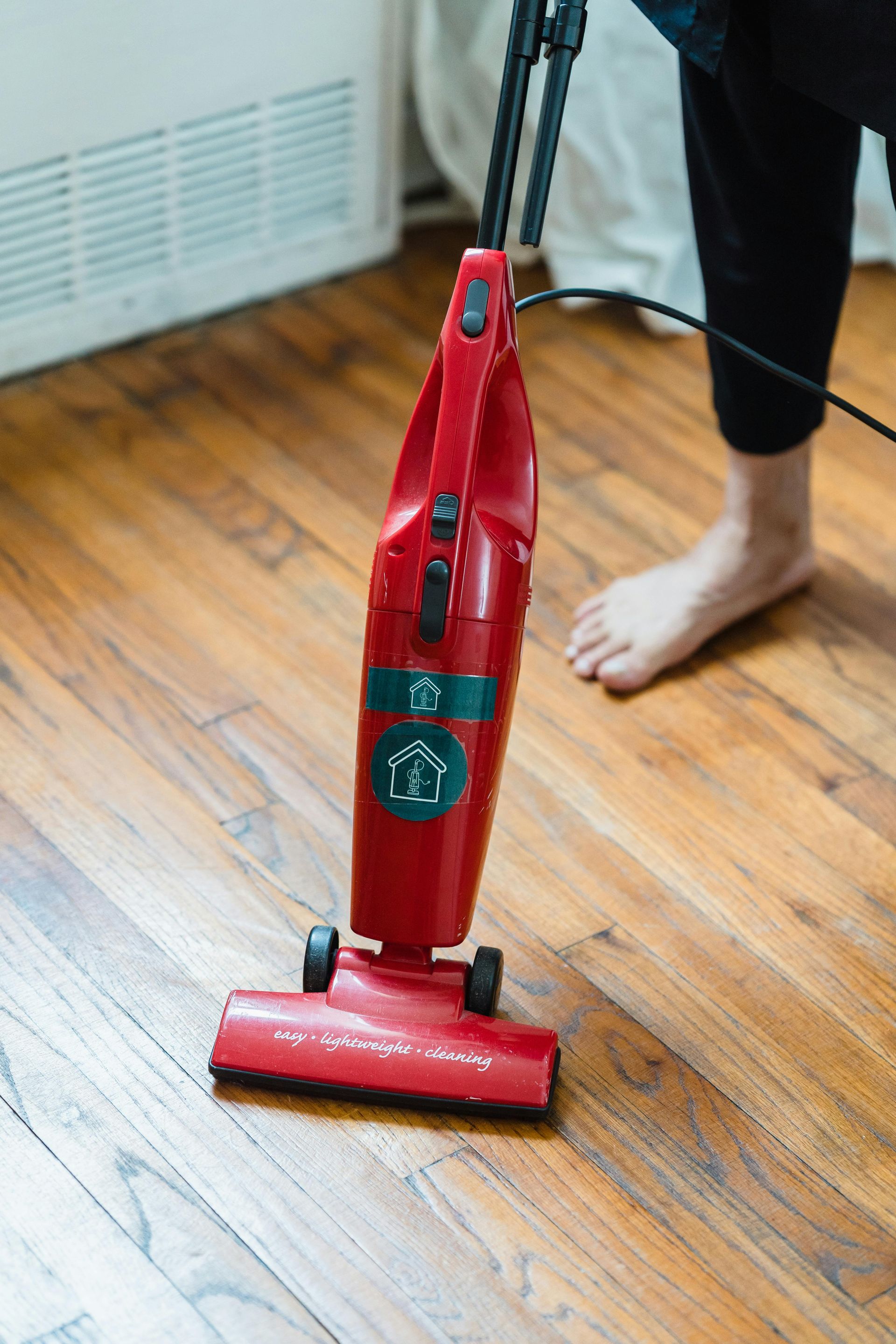 Vacuum cleaning hardwood floors during regular maintenance routine