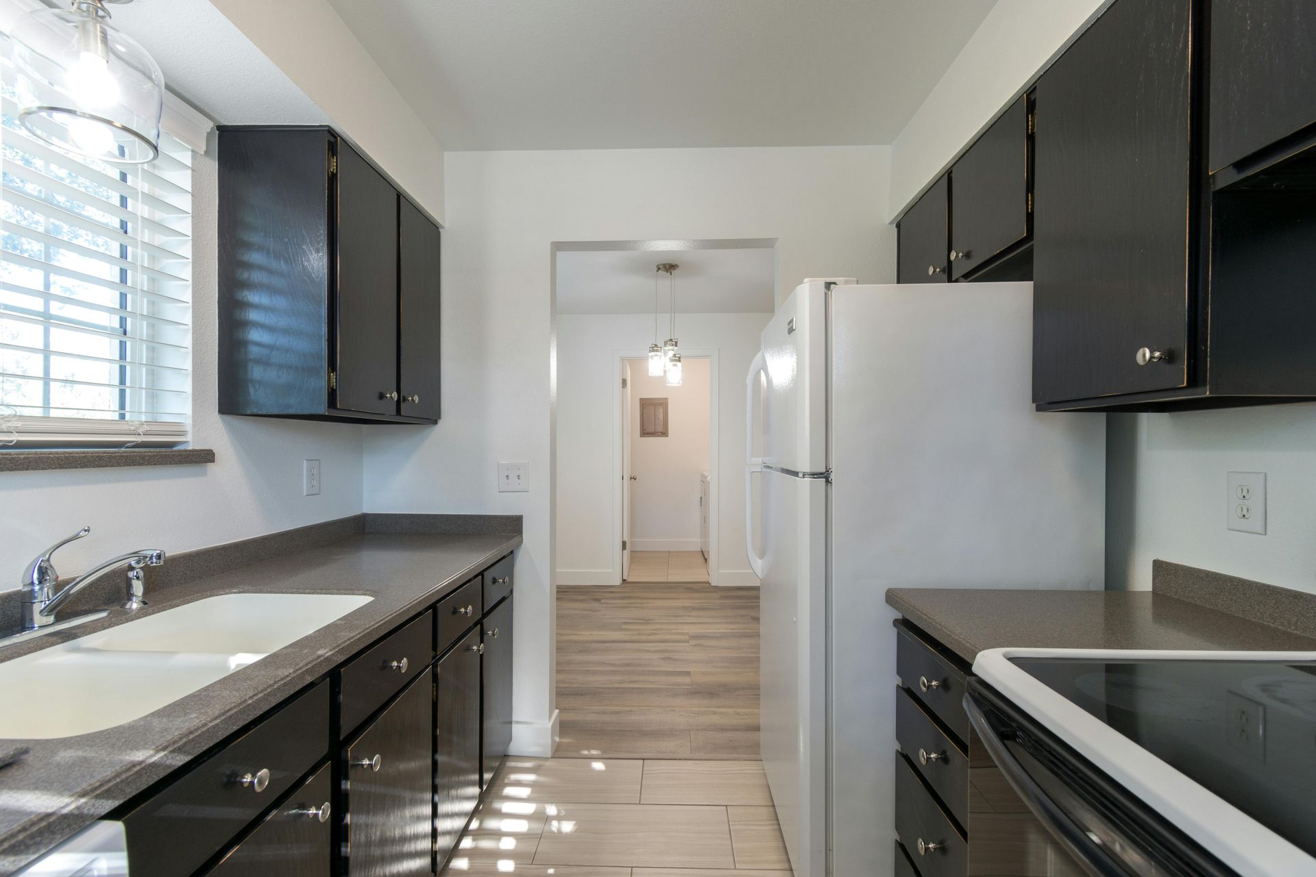 Galley kitchen layout with dark cabinets and granite countertops in Lexington NC