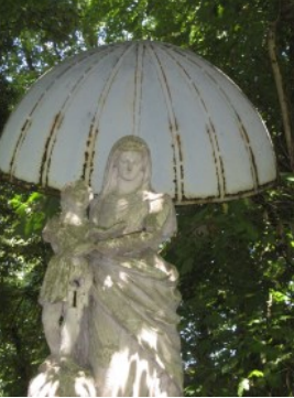 Statue d'une femme tenant un enfant, abritée par une grande structure en forme de dôme.