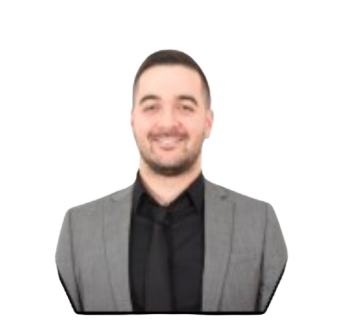 Un homme souriant, portant un blazer gris, une chemise noire et une cravate.