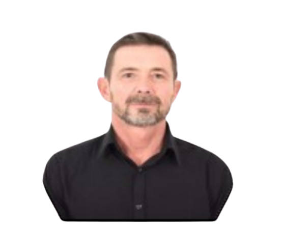 Un homme à la barbe grisonnante et à la chemise sombre regarde l'objectif.