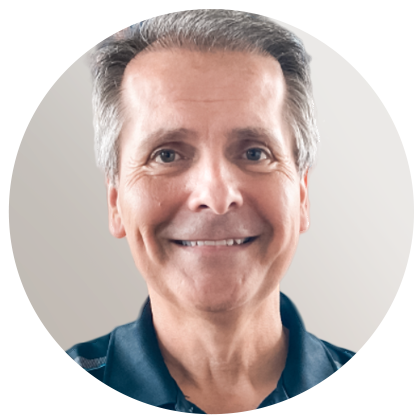 Portrait d'une personne souriante portant une chemise blanche à col et un blazer foncé texturé sur un fond bleu clair.