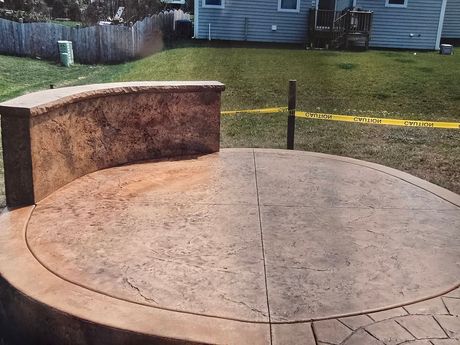 A patio with a picnic table and benches under an umbrella.