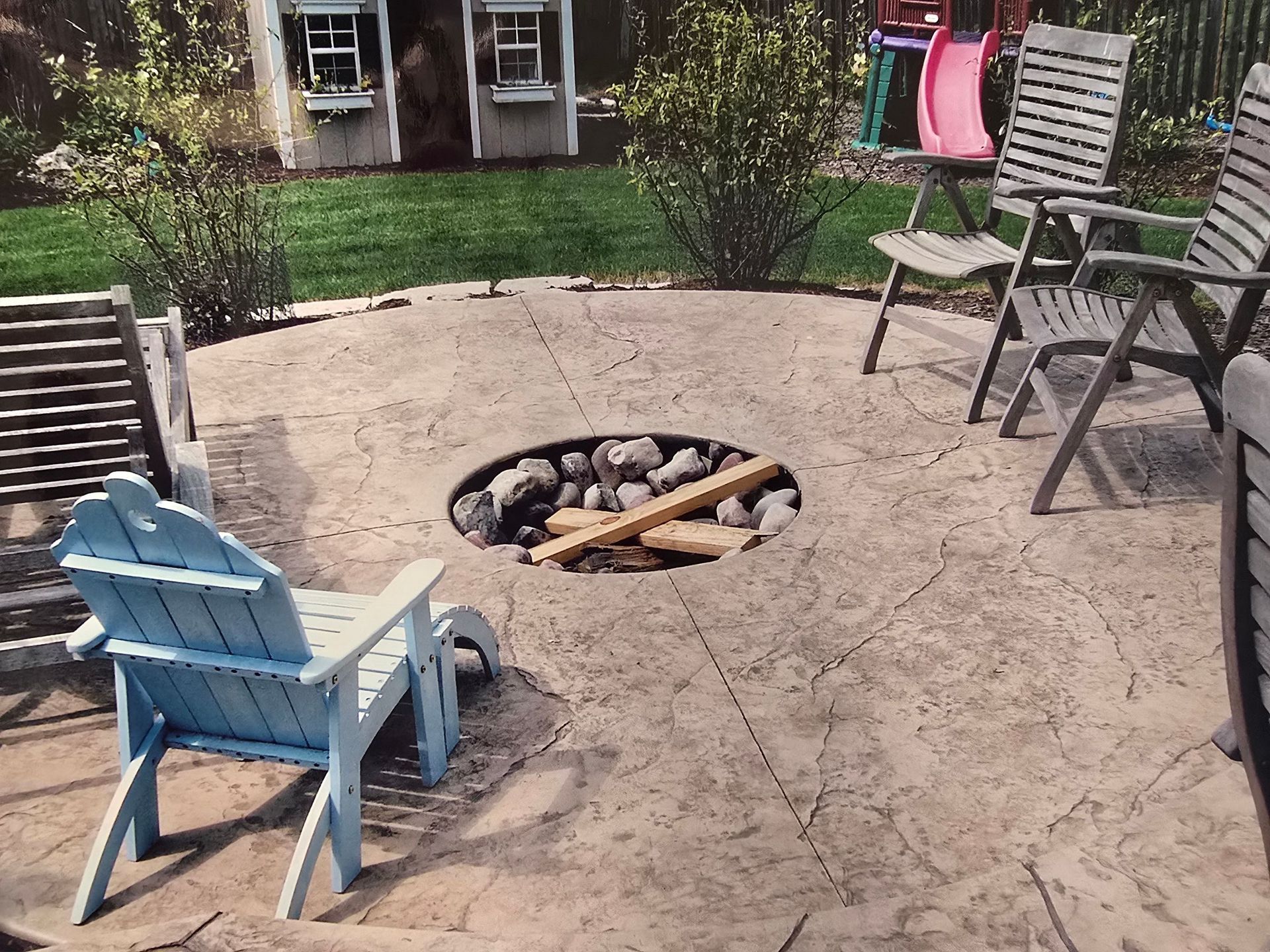 A patio with a table and chairs and a ceiling fan overlooking a pool.