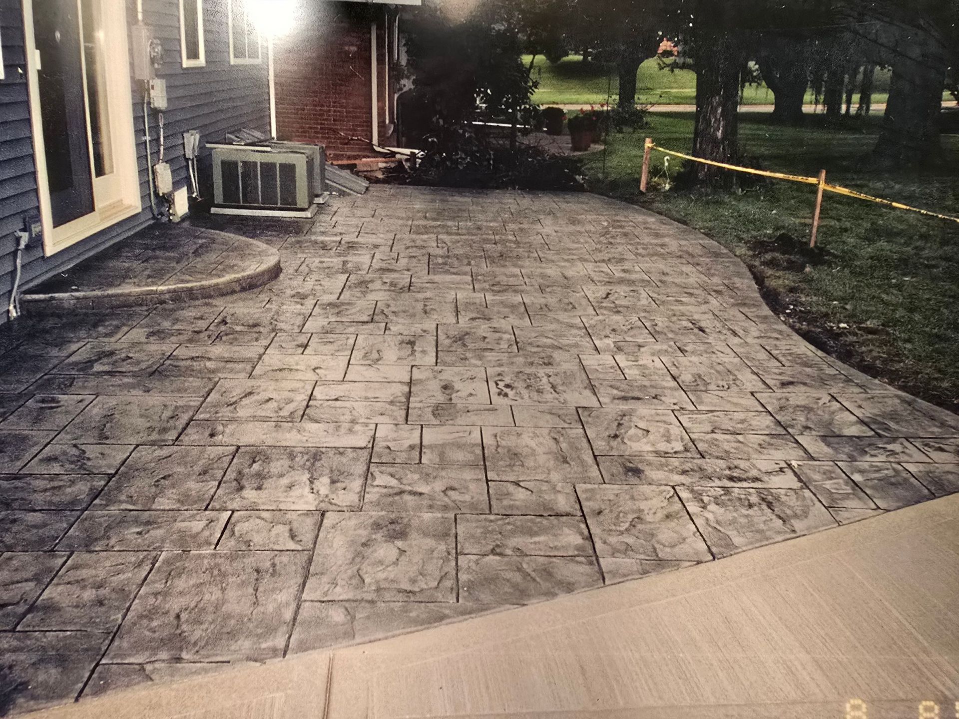 A brick walkway with a pond in the middle of it.