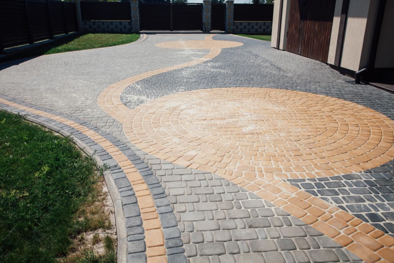 A brick driveway with a circular design in the middle of it.