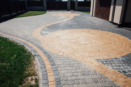 A brick driveway with a circular design in the middle of it.