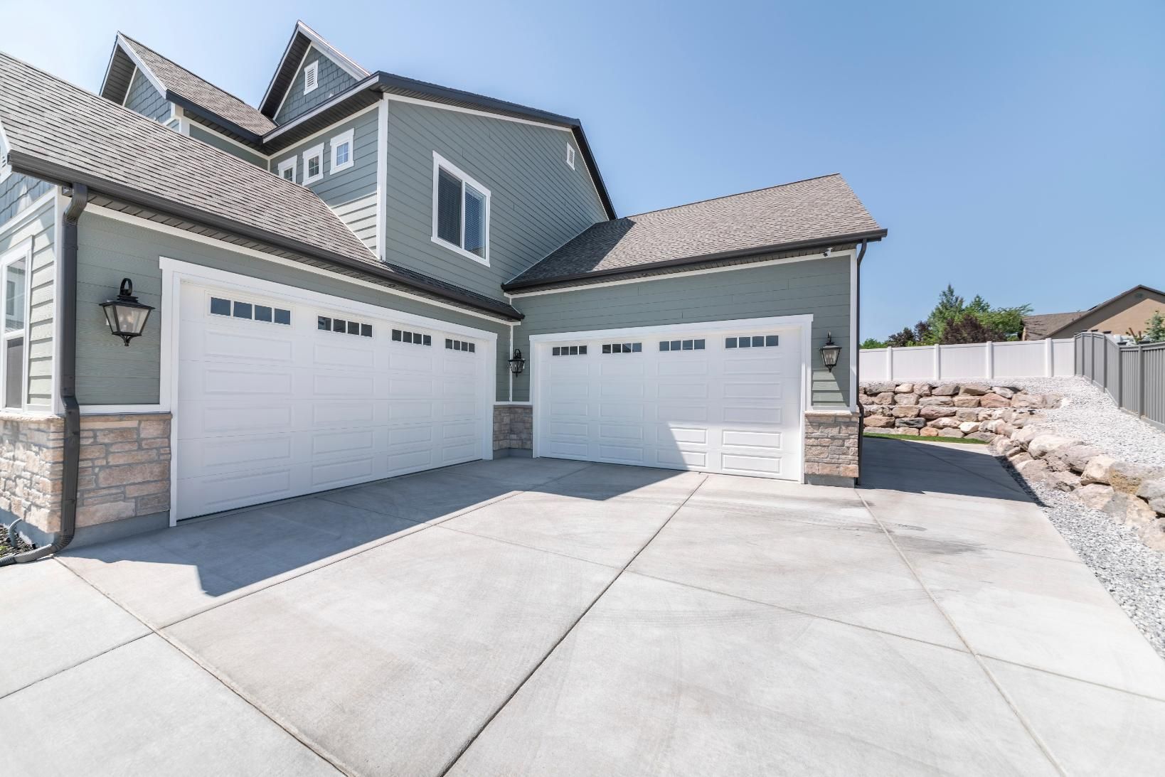 A large house with a lot of garage doors and a concrete driveway.
