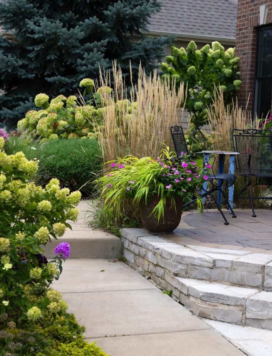 A patio with a chair and a potted plant.
