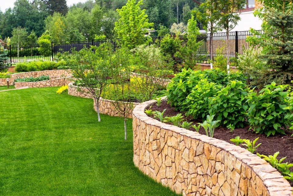 There is a stone wall in the middle of the garden.