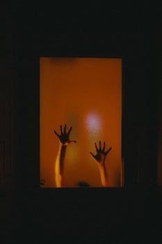 A person 's hands are reaching out of a window.