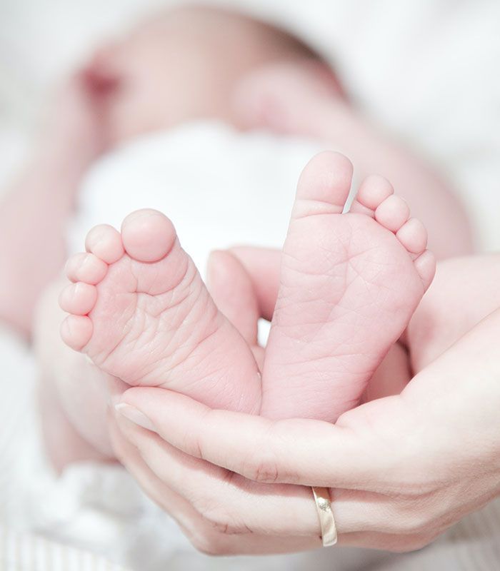Newborn baby feet being held by caregiver