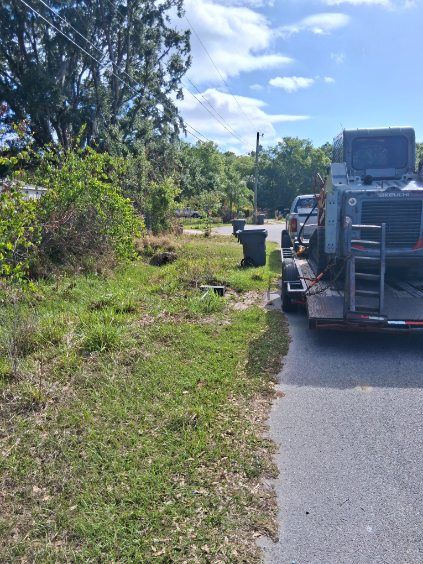 Parked utility truck on a roadside with grass, trees, and a partly cloudy sky