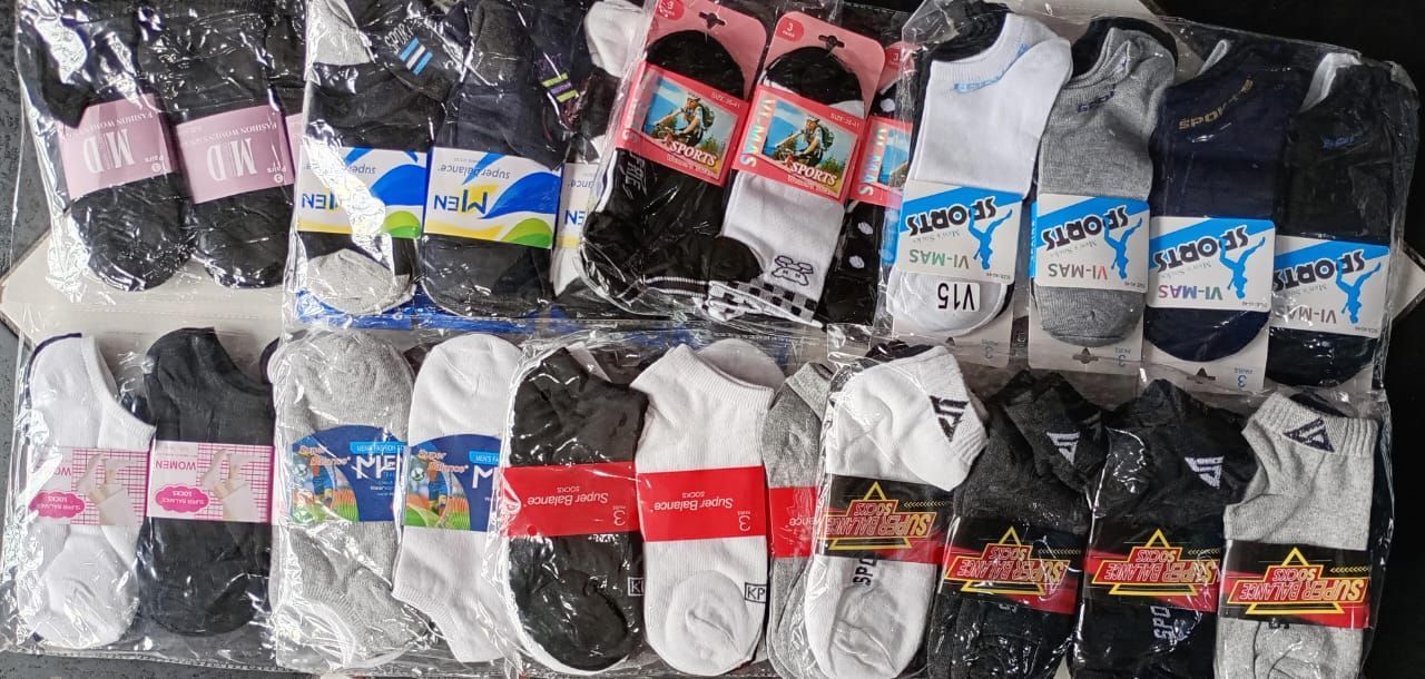 Surtido de calcetines empaquetados en varios colores, incluidos blanco, negro, gris y azul, expuestos juntos.