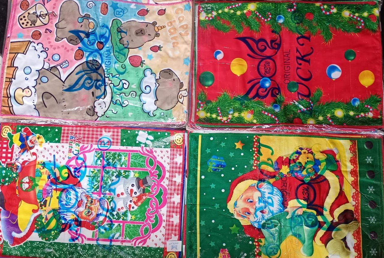 Cuatro toallas de plástico con estampados coloridos: gatos, escenas navideñas y Papá Noel.