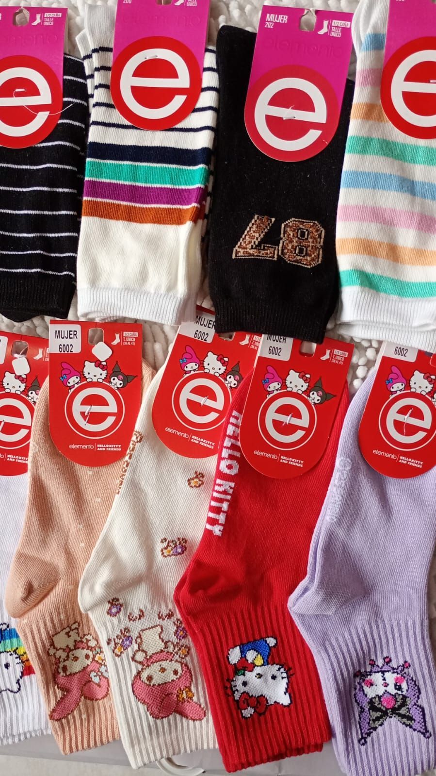Calcetines surtidos con diversos diseños, incluyendo rayas, números y personajes de Hello Kitty.
