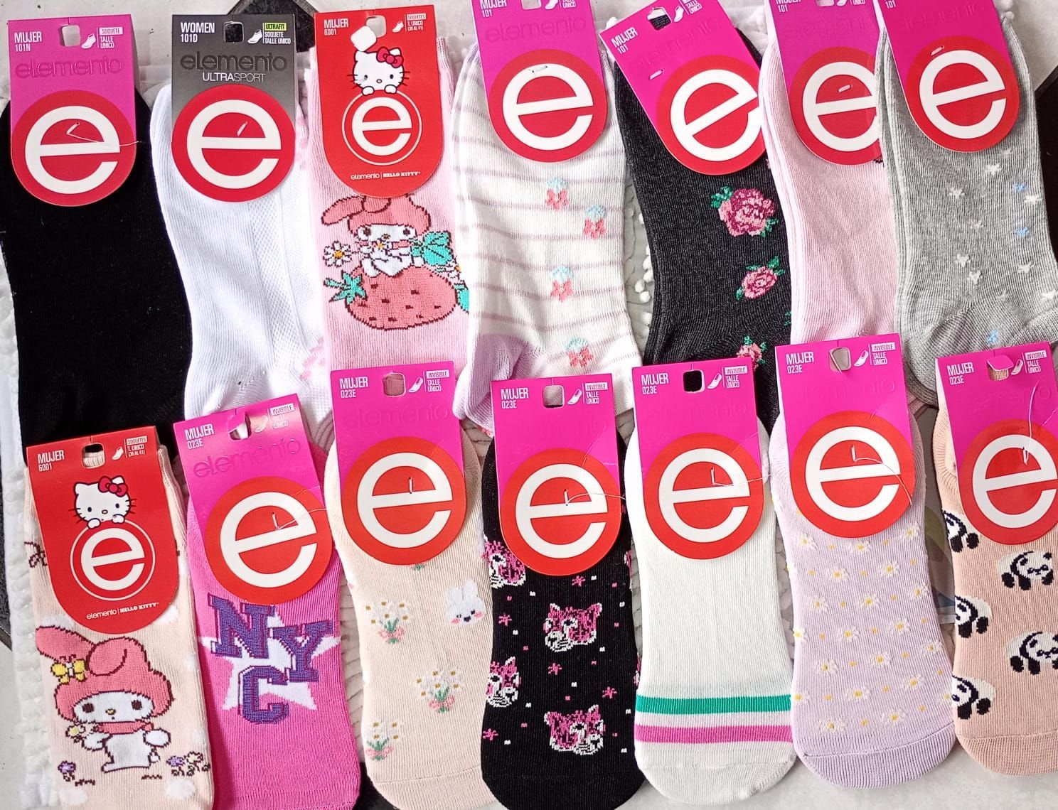Calcetines coloridos con etiquetas rosas, con diversos estampados como flores y Hello Kitty.