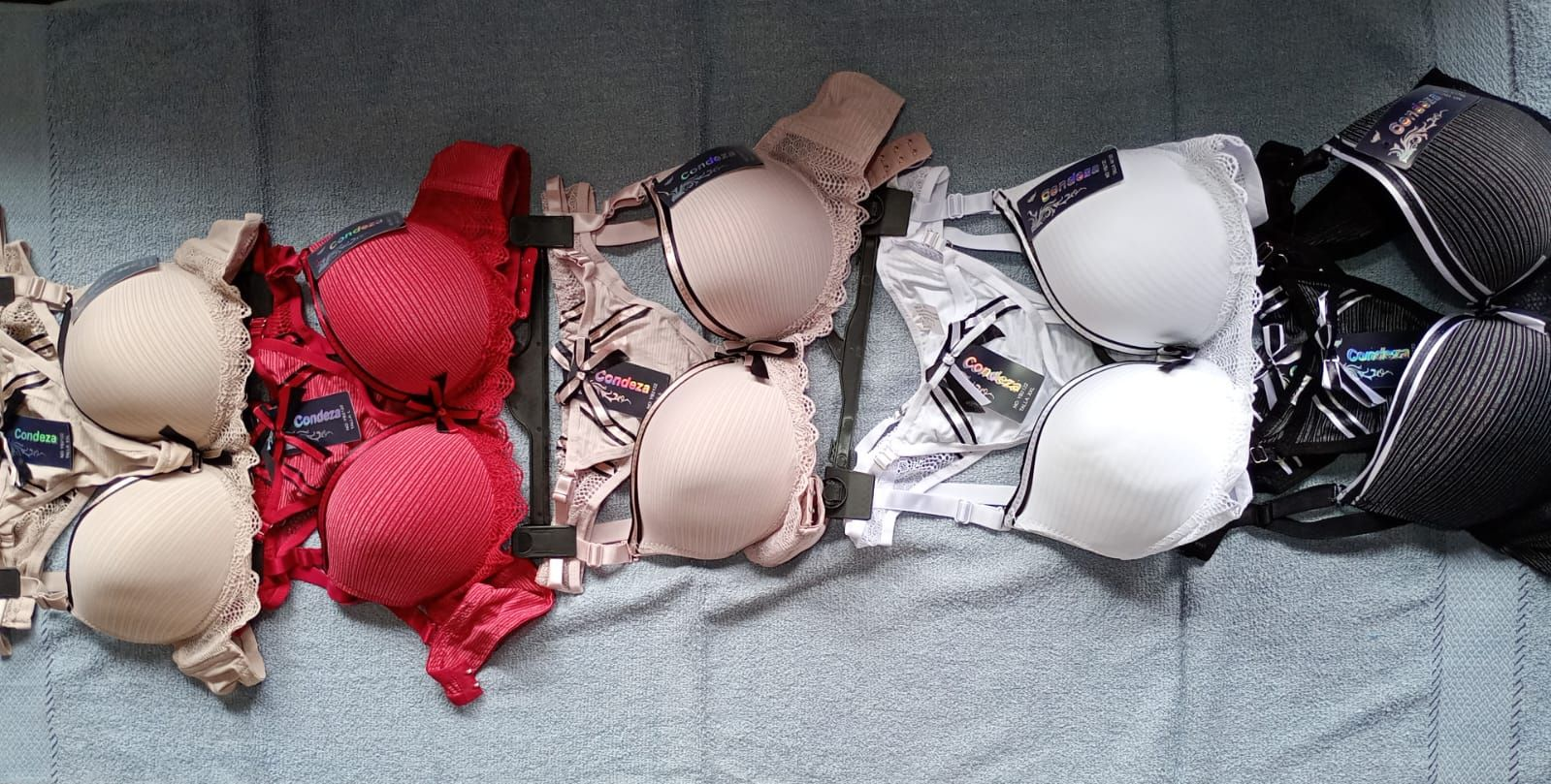 Sujetadores de varios colores dispuestos sobre una superficie gris.