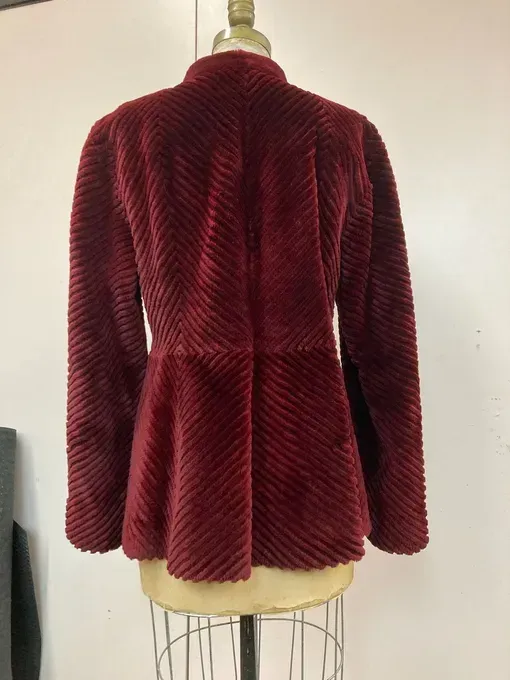 Burgundy faux fur jacket on a dress form, featuring a peplum and stand collar.