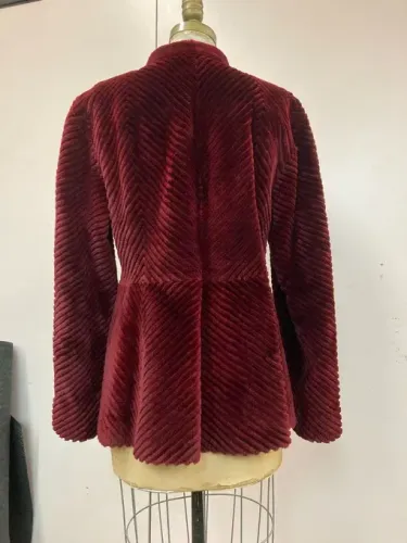 Burgundy faux fur jacket on a dress form, featuring a peplum and stand collar.