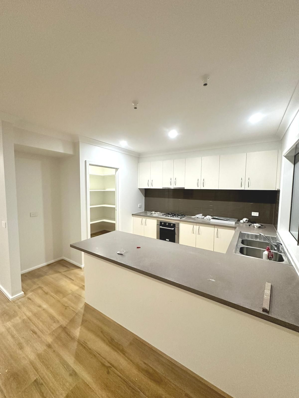 A kitchen with white cabinets , stainless steel appliances , and a large island.