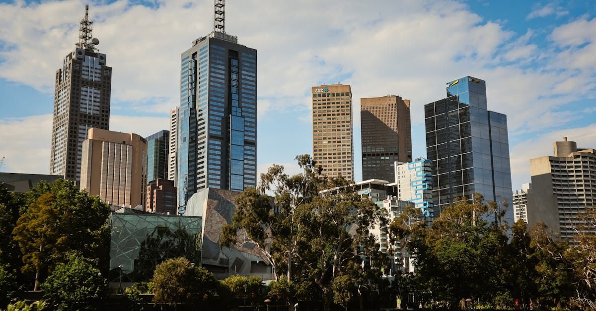 A city skyline with a lot of tall buildings and trees in the foreground.