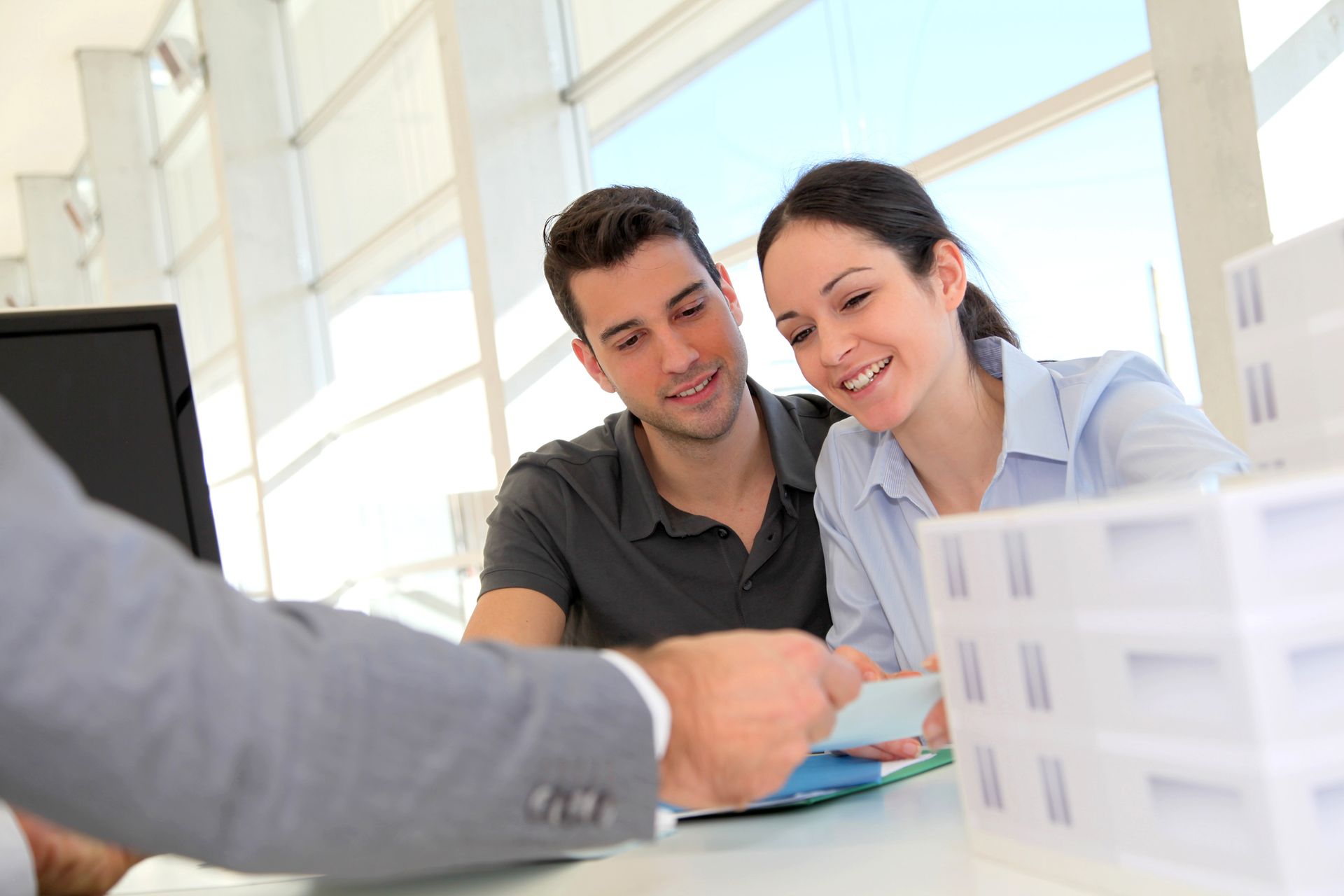 A couple reviews documents at a desk, exploring Home Mortgage Loans at Clift Mortgage in Sequim, WA.