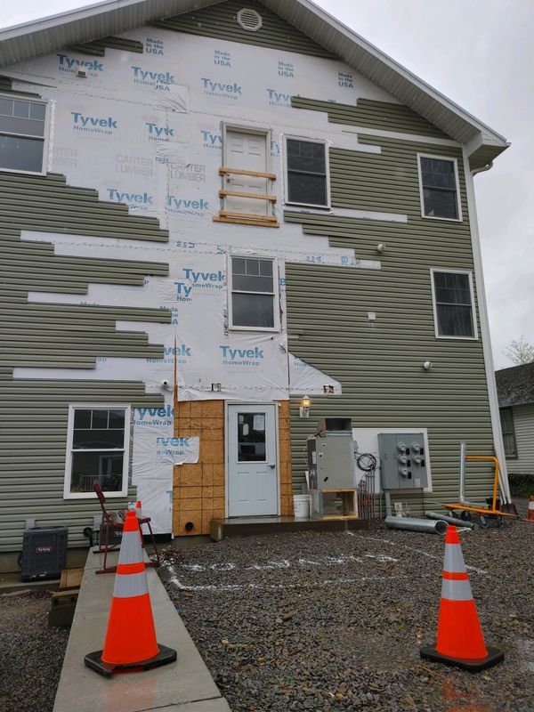 A building with a lot of siding on it is being remodeled.