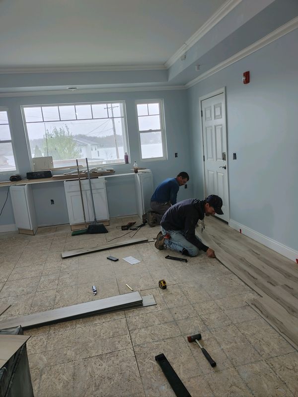 Two men are kneeling on the floor in a room.