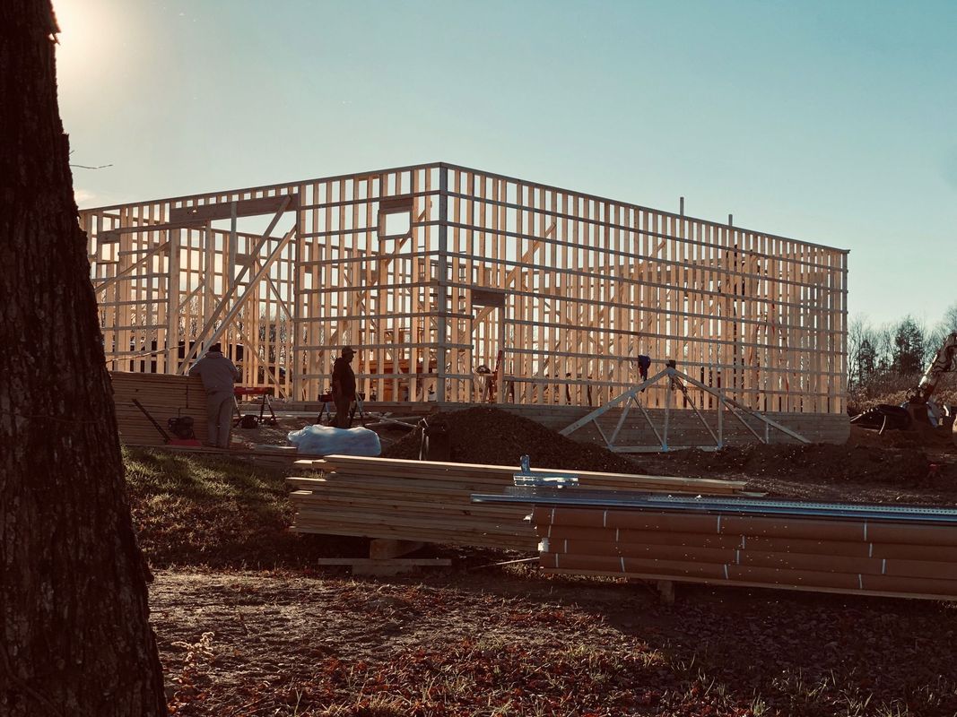 A large wooden structure is being built on a sunny day.