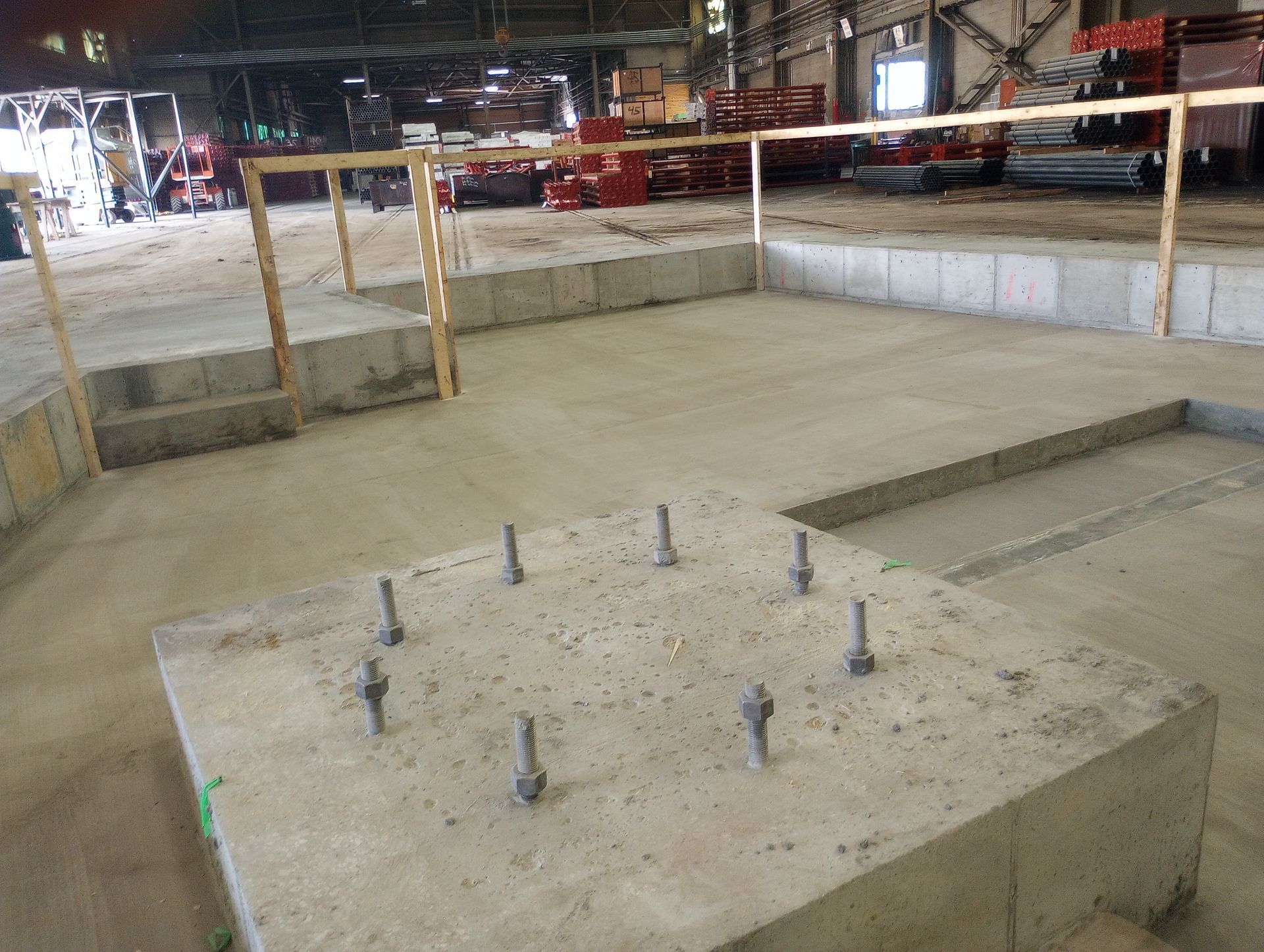 A concrete block with screws in it is in a building under construction.