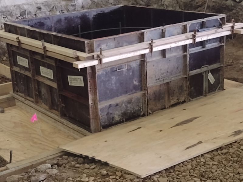 A large container is sitting on top of a wooden platform.
