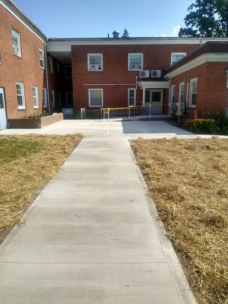 A brick building with a concrete walkway leading to it