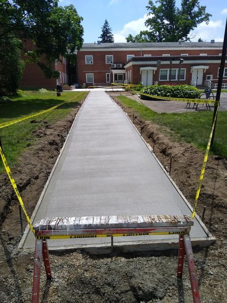 A concrete walkway is being built in front of a building