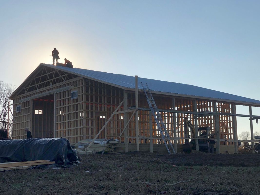 Two men are working on the roof of a building under construction