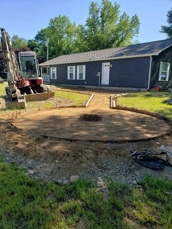 A bulldozer is digging a hole in the dirt in front of a house.