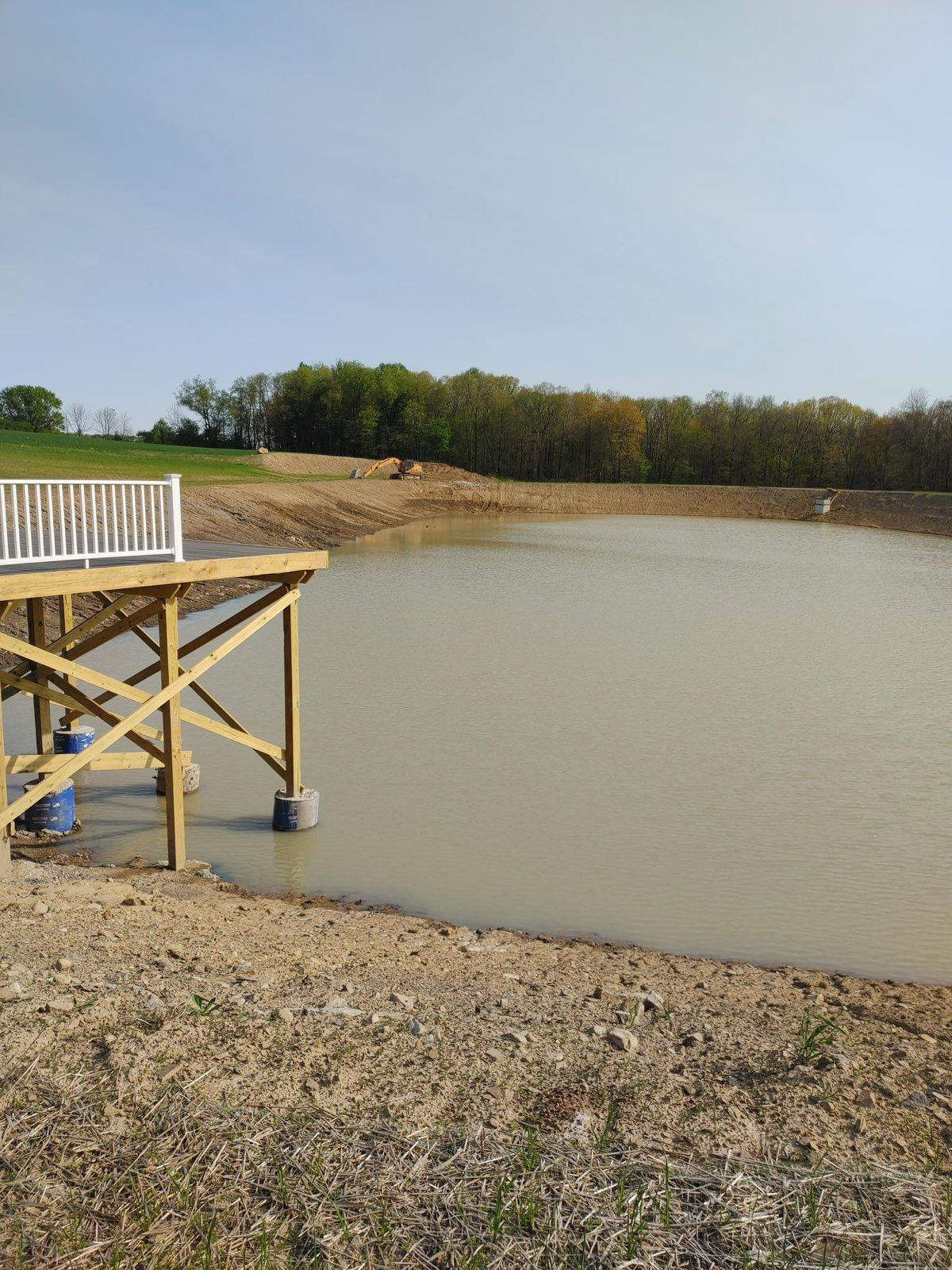 A wooden dock is sitting next to a large body of water.