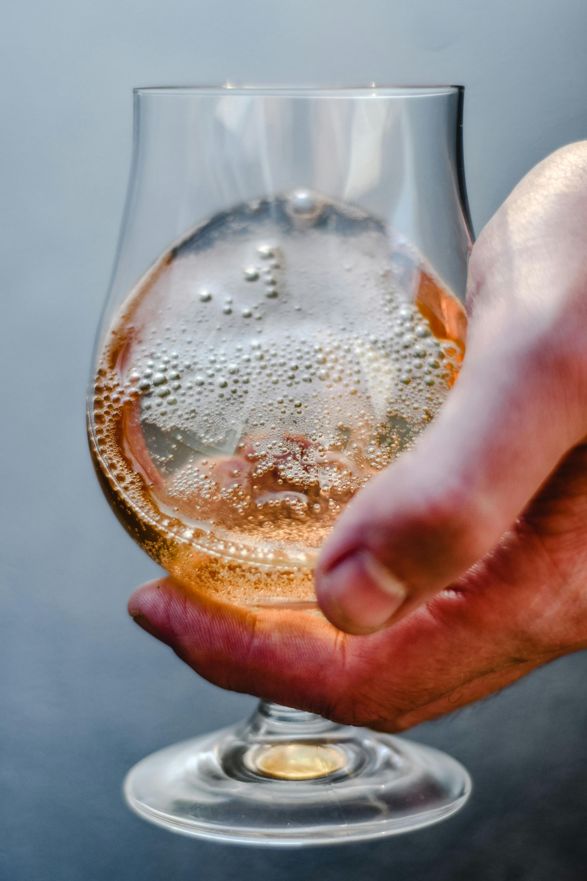 A person is holding a glass of beer in their hand.