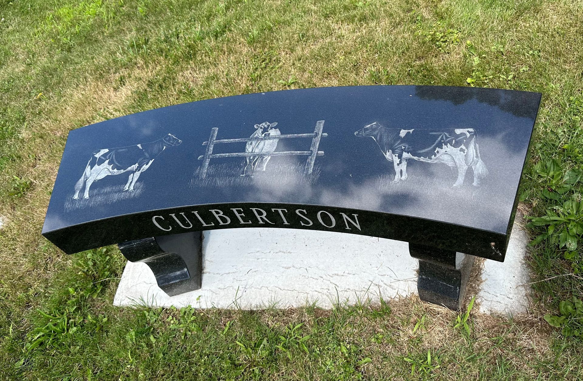 A black curved bench with the name culbertson on it
