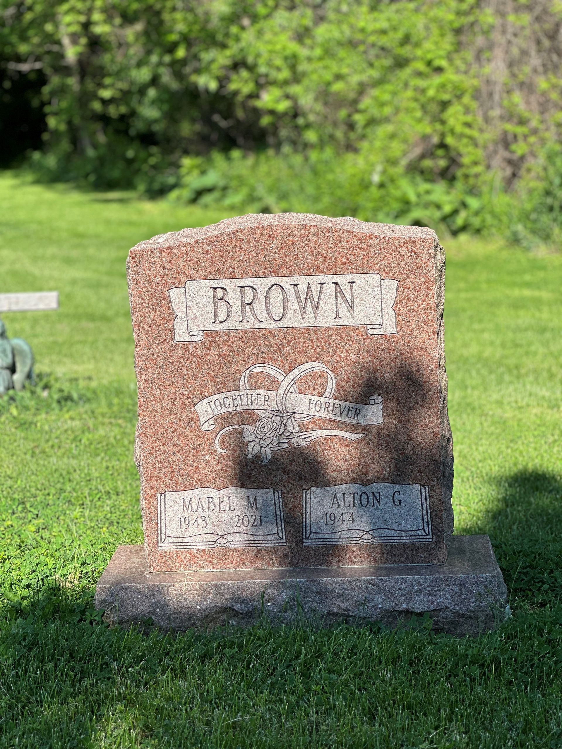 A gravestone in a cemetery with a shadow on it.