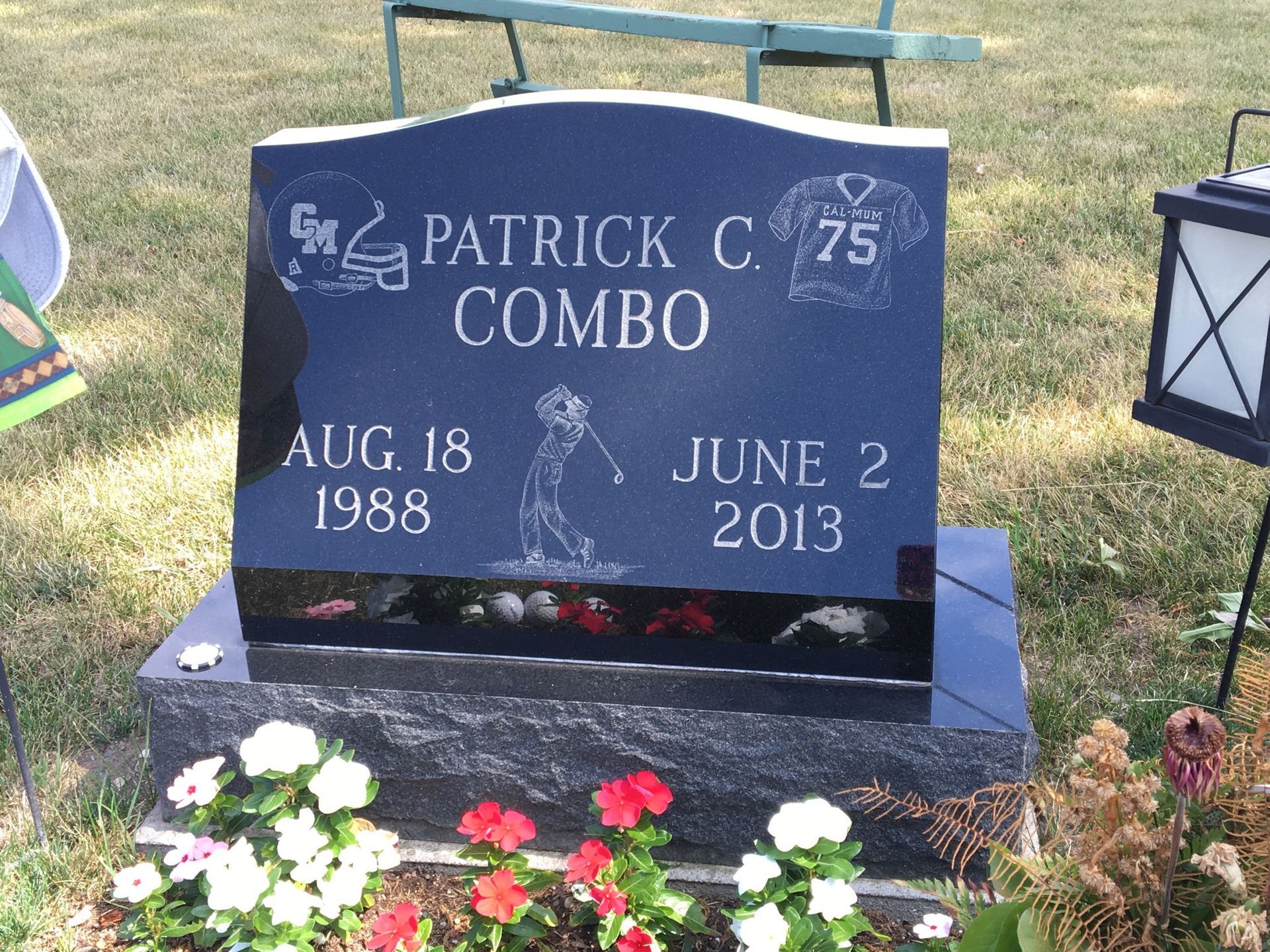 Black headstone for Patrick C. Combo, with birth/death dates, a golf silhouette, football graphics, and surrounding flowers.