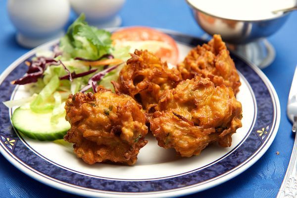 A plate of food with fried food and vegetables on a table.