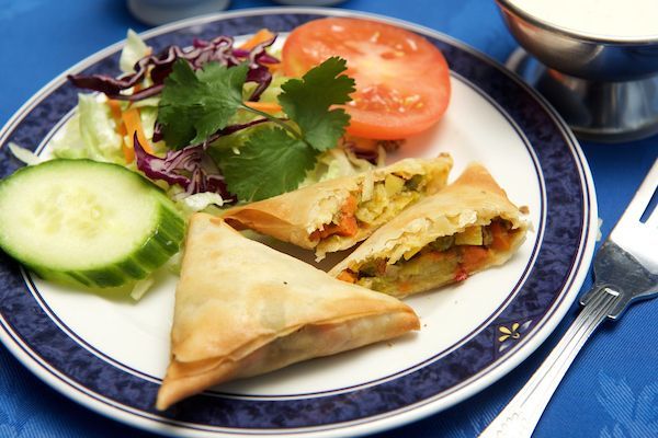 A plate of food with vegetables and a fork on a table