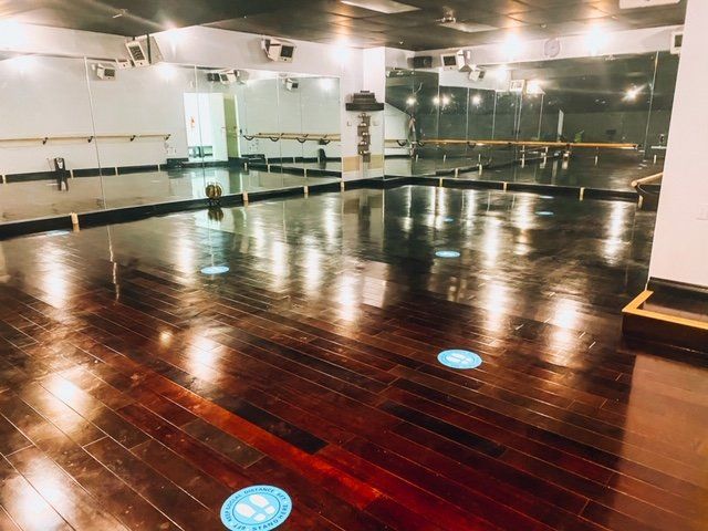 an empty dance studio with a wooden floor and mirrors