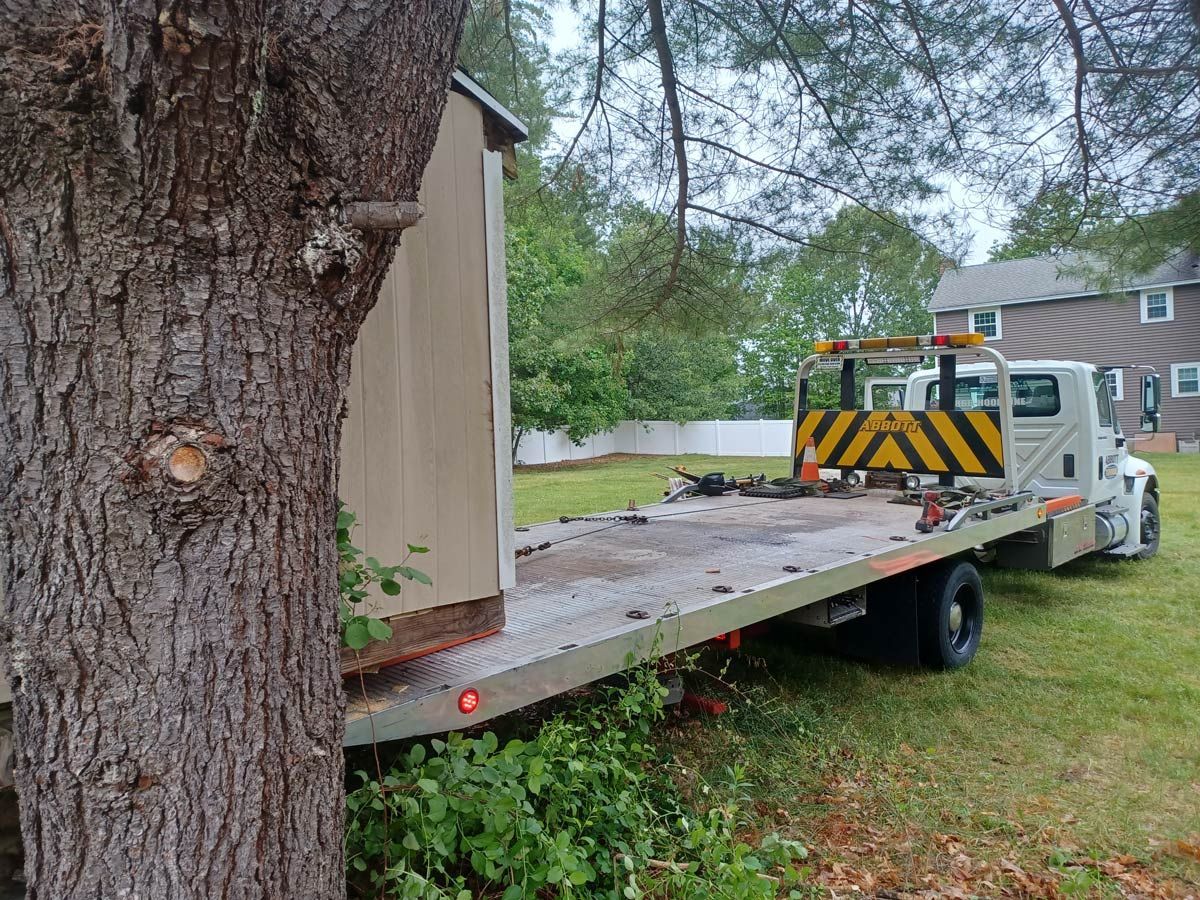 A Truck with A Shed Parked Next to A Tree — Hudson, NH — Abbott Towing Service