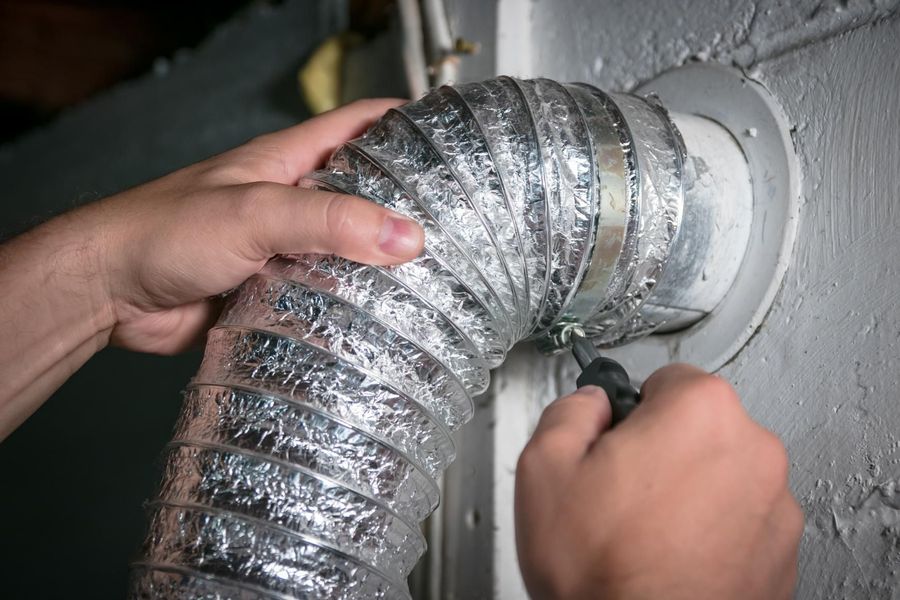 A brush is being used to clean a vent on the ceiling.